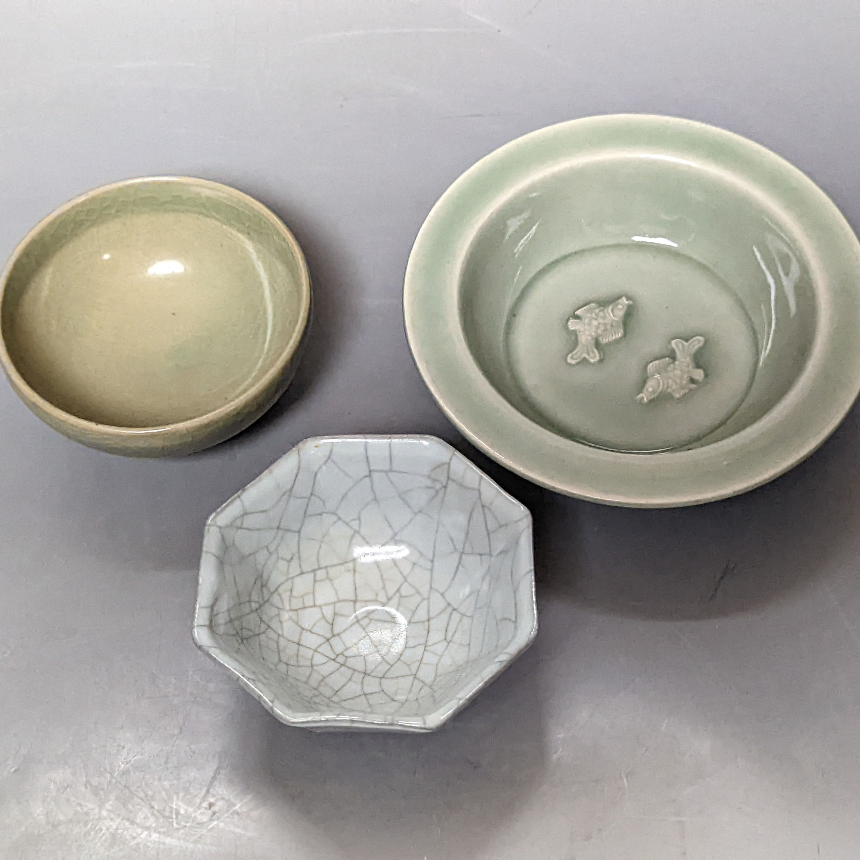 A Chinese celadon glazed twin fish brushwasher, 13.2cm, a celadon glazed cup and a crackle glaze cup (3)